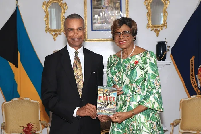 Tellis Bethel presents a copy of his book to the Governor General