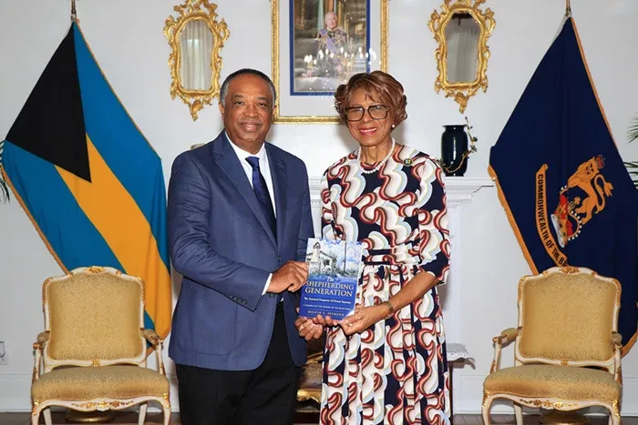 Mr. Melvin Seymour presents a copy of the book to the Governor General