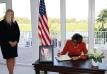 Governor General Dame Cynthia Pratt signs the Book of Condolence for Former US President Jimmy Carter